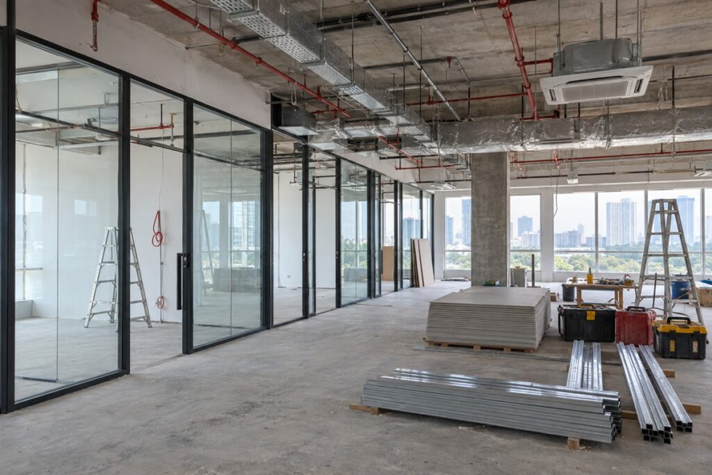 Office renovation site with glass partitions and cable trays above